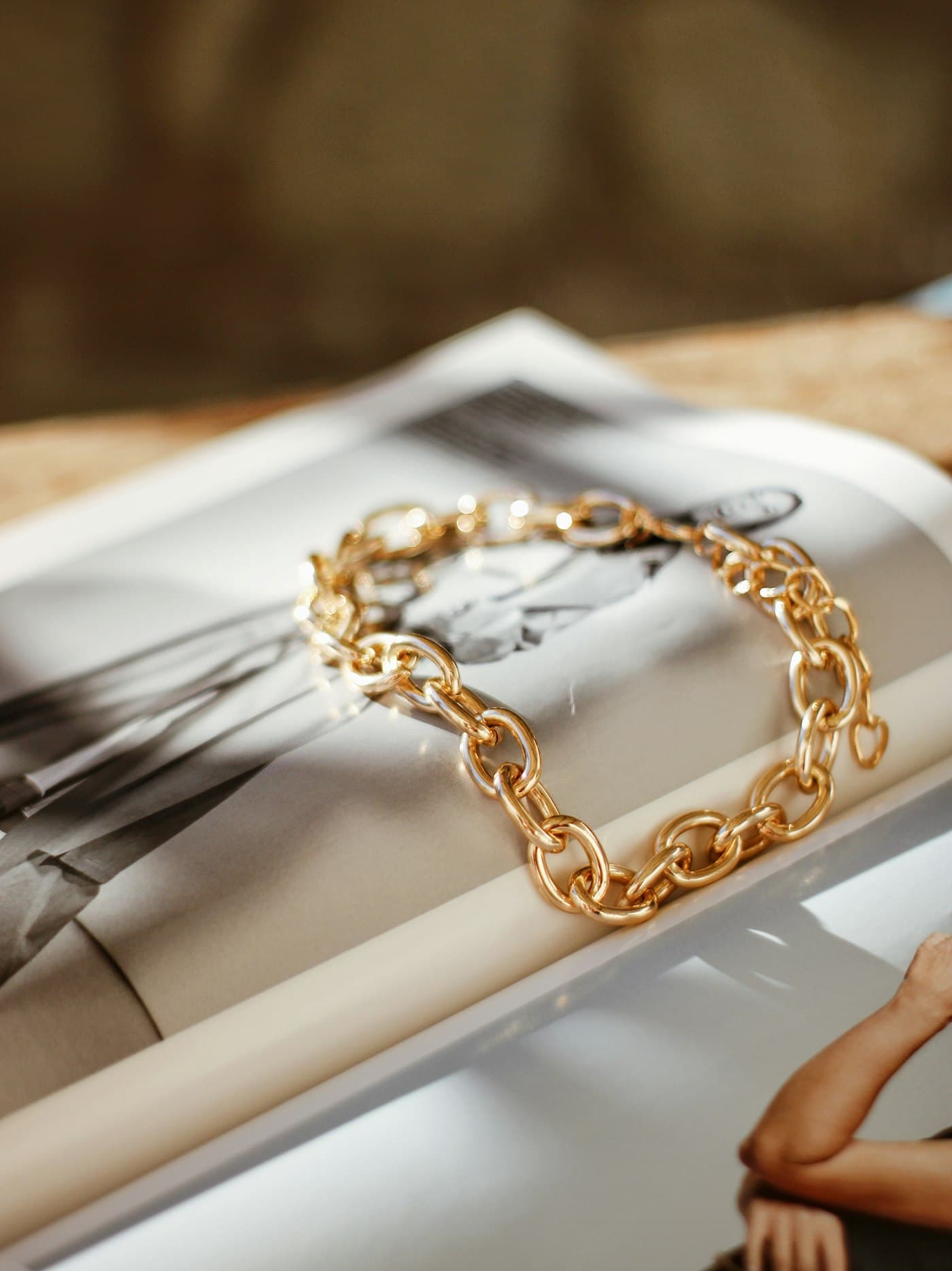 Bracelet Platinum Maillon, chaîne dorée à maillons larges posée sur un magazine