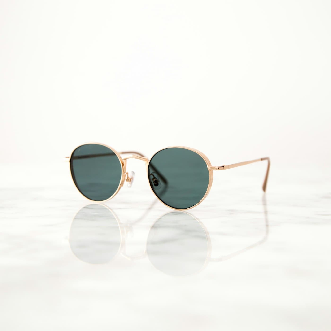 Lunettes de soleil Platinum à monture ronde dorée sur marbre clair