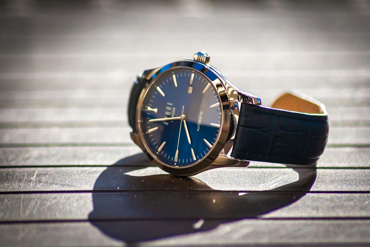 Montre Platinum Signature à cadran bleu soleillé posée sur un plan clair