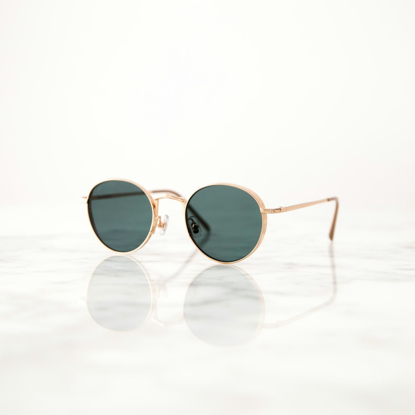 Lunettes de soleil Platinum à monture ronde dorée sur marbre clair