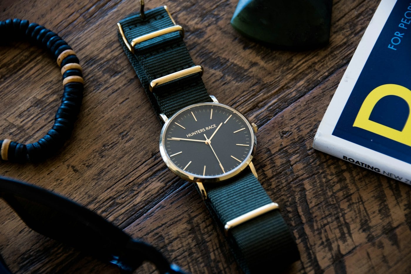 Montre Platinum Urban à bracelet textile vert, posée sur un plan en bois